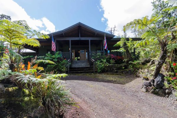 Volcano Estate exterior with driveway surrounded by lush ferns