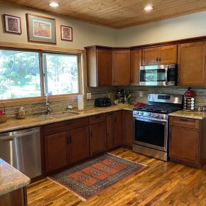 Kitchen sink and stainless appliances with rainforest view